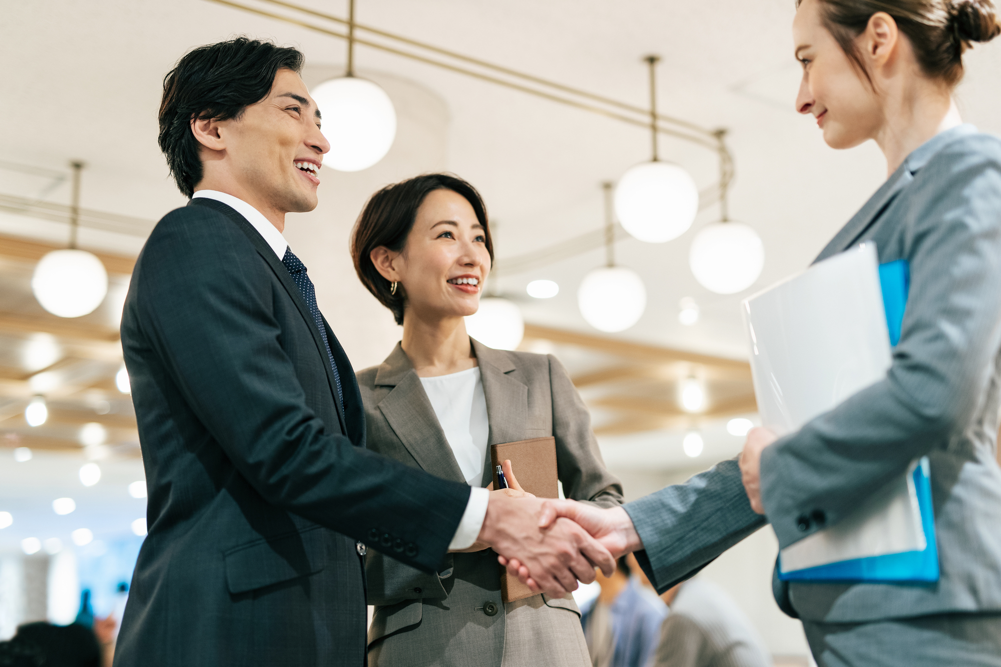 商談で握手を交わすビジネスパーソン